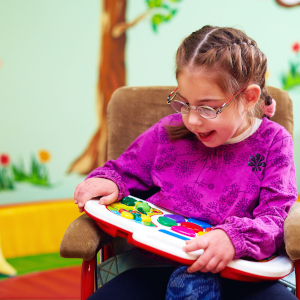 Ήρωες της BPAN cute girl in wheelchair playing with developing toy in kindergarten for children with special needs